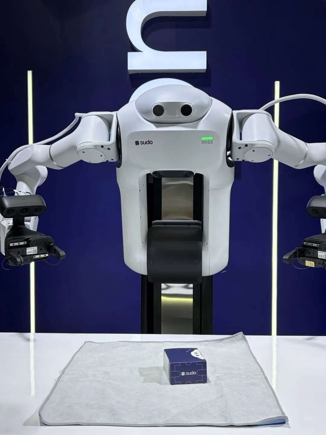 Sudo robot wrapping a gift box with cloth at WAIC 2026
