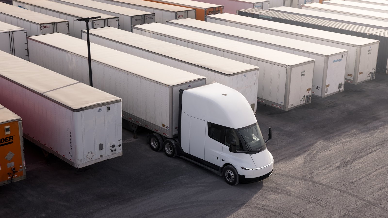 Tesla Semi parked beside warehouse loading bays