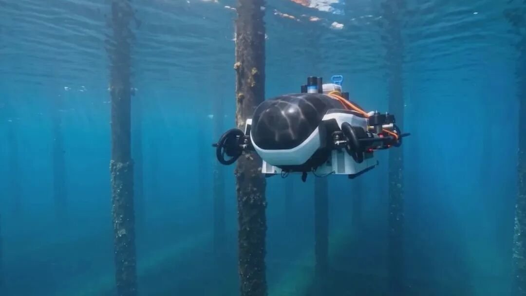 Commercial diver in full gear descending through blue water