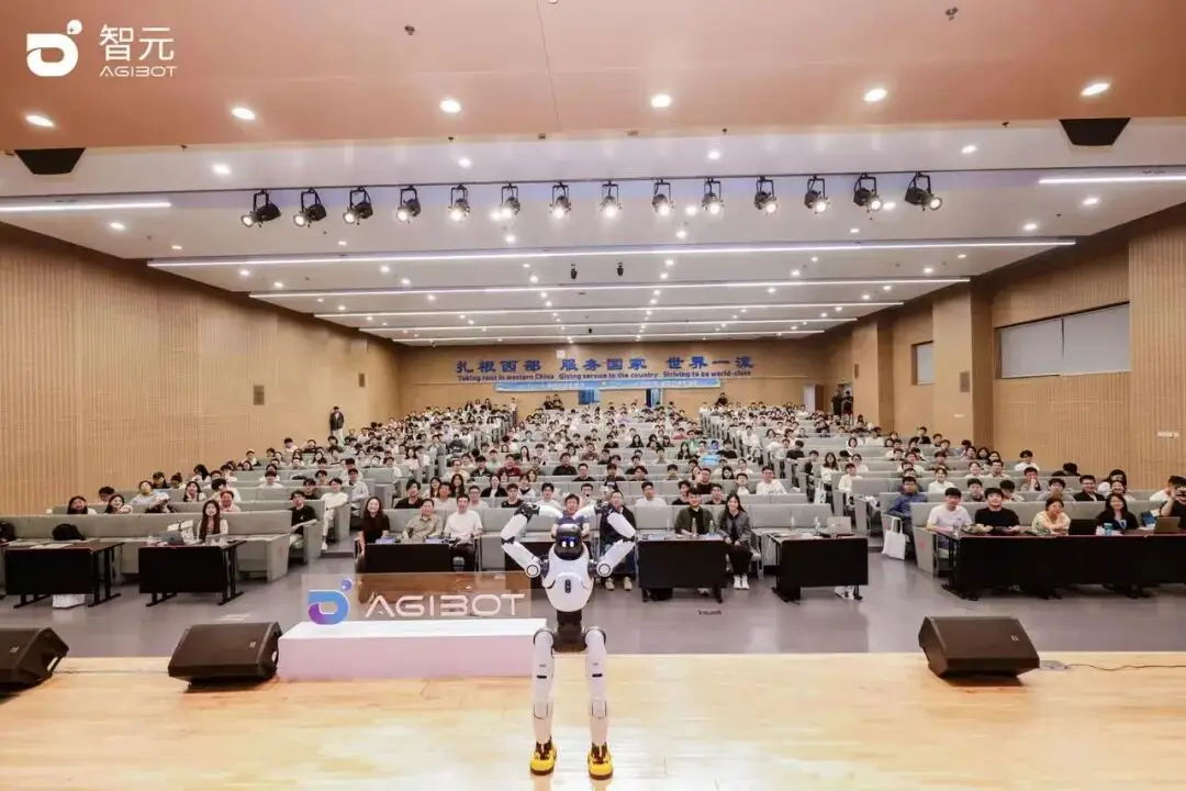 Agibot humanoid robot demonstrating on stage in front of a university auditorium