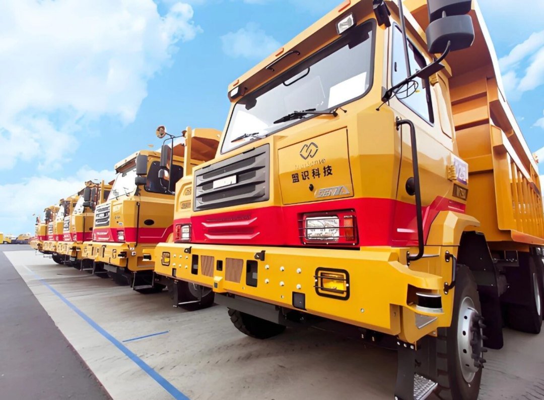 Row of yellow and red autonomous mining haul trucks built by Mengshi Technology