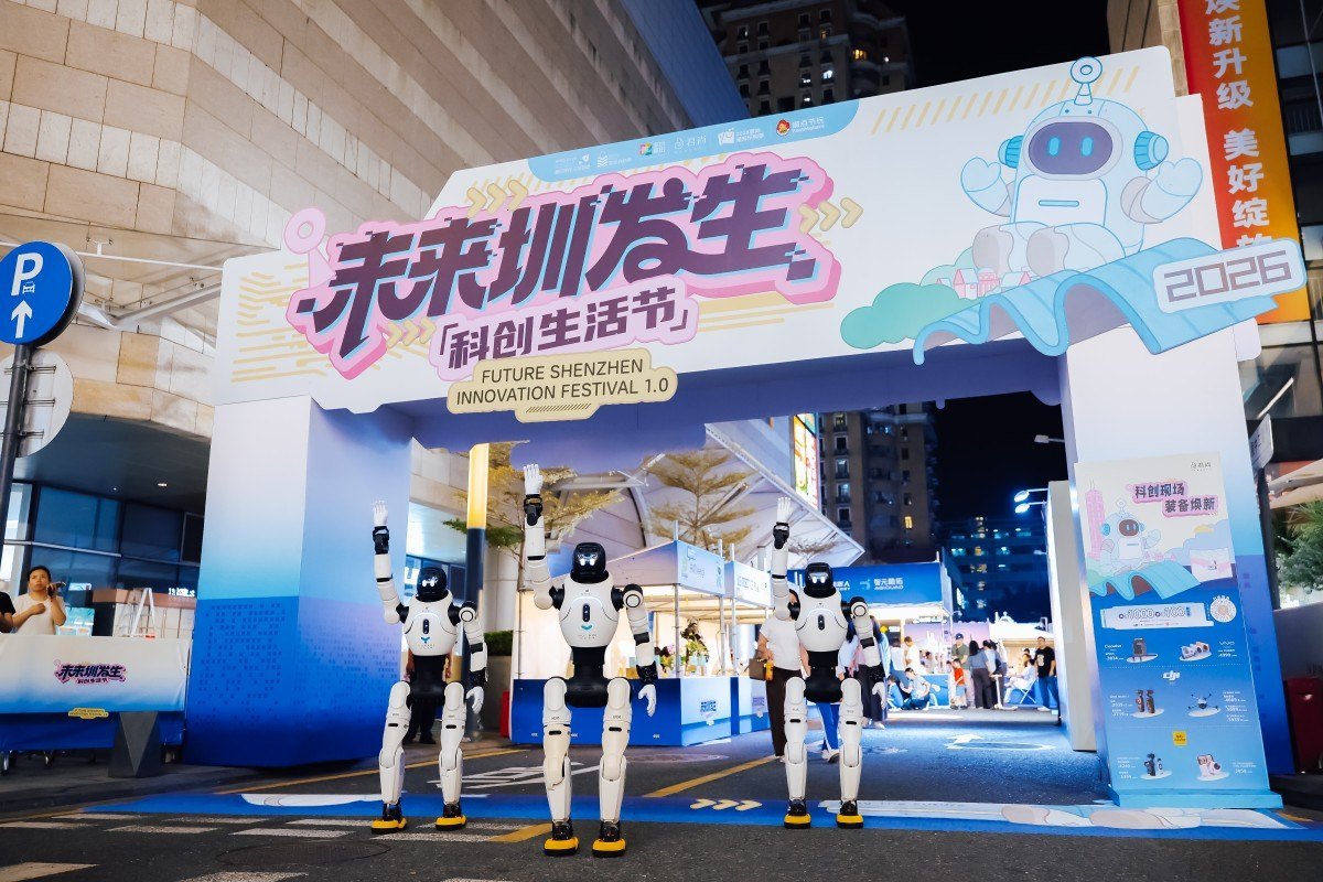Visitors trying interactive robots at a Shenzhen shopping mall technology festival