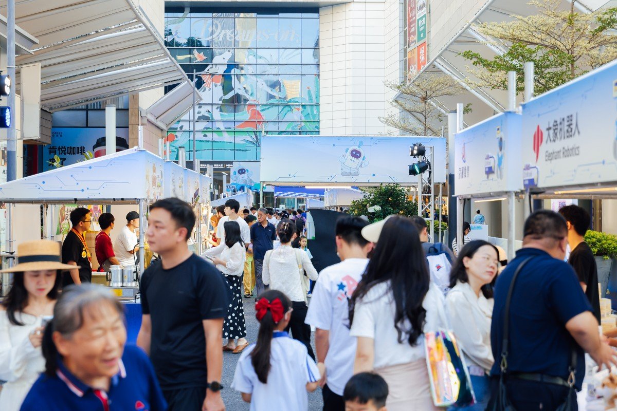 Visitors interacting with a robot dog at the Huaqiangbei tech-life festival in Shenzhen